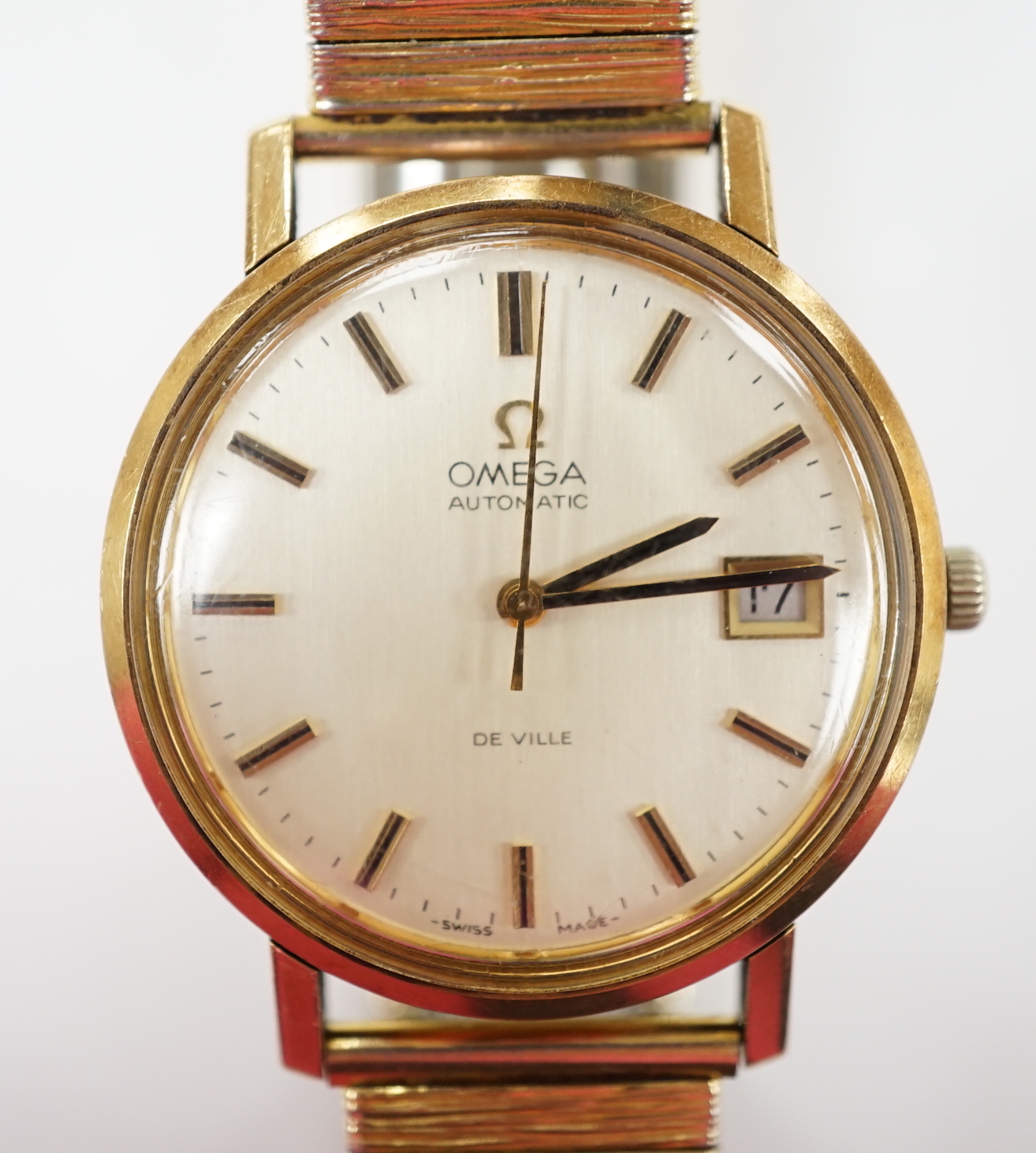 A gentleman's yellow metal Omega De Ville automatic wrist watch, with baton numerals and date aperture, case diameter 34mm, on an associated gold plated bracelet.